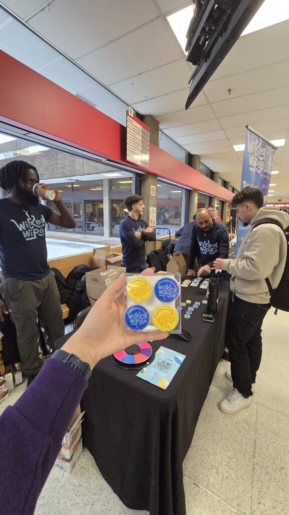 Holding Wicked Wipes hand wipes at a University event